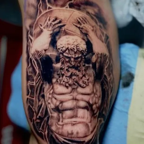 Black and grey realism tattoo of a muscular bearded figure rendered like a stone statue, arms raised overhead as if bearing great weight, on the bicep.