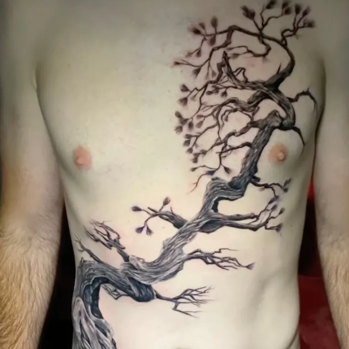 Black and grey tattoo of a gnarled, leafless tree branch winding from the chest down across the stomach.
