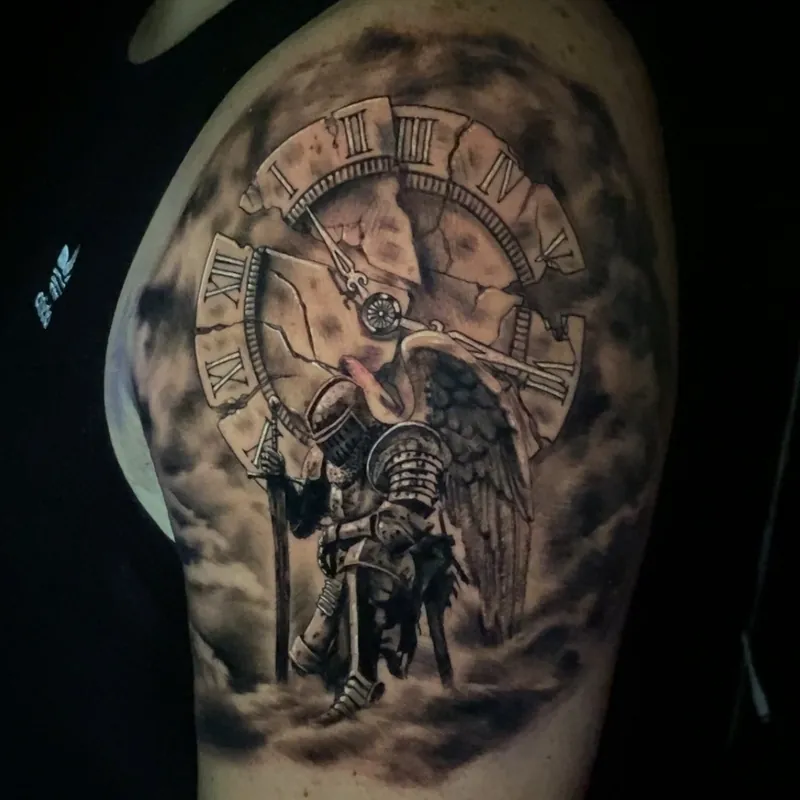 Black and grey tattoo of an armored knight with a single angel wing holding a sword, kneeling before a cracked stone clock face, on the shoulder.