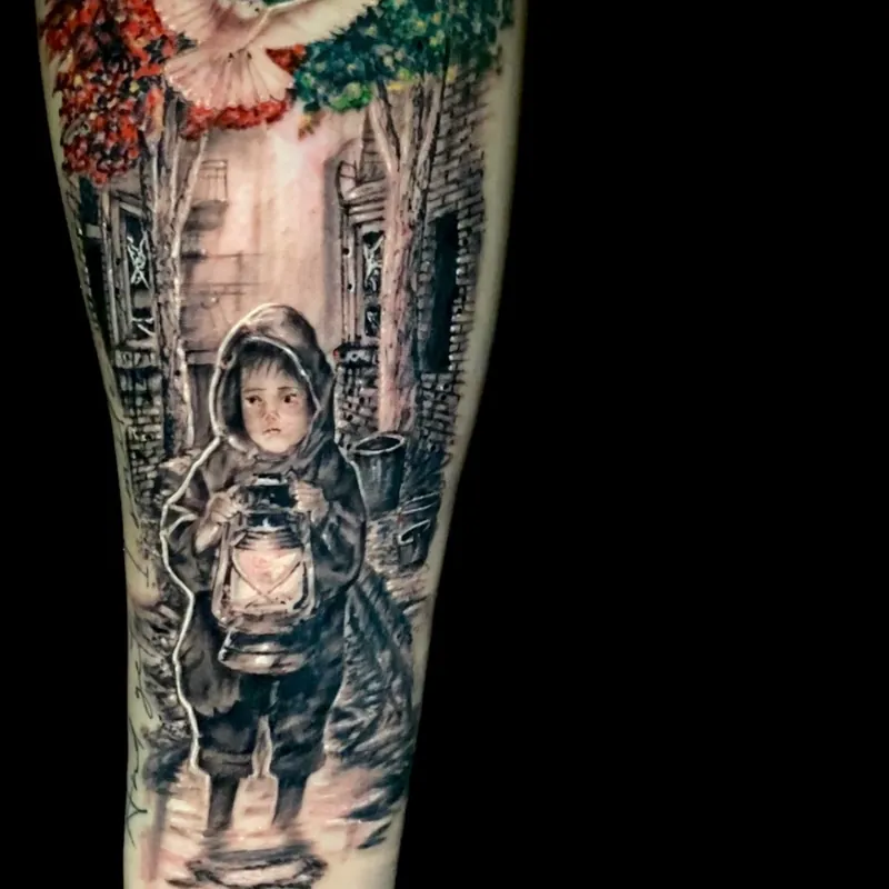 Color tattoo on the forearm of a hooded child holding a glowing lantern amid ruined buildings, cursive script lettering along the arm, dove and colorful treetops above.