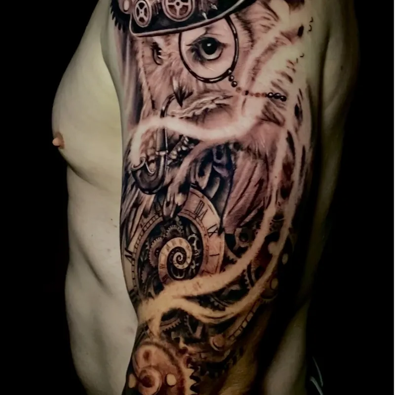 Black and grey steampunk tattoo on the upper arm of an owl wearing a gear-covered top hat and monocle, smoking a pipe above a gear-filled pocket watch.