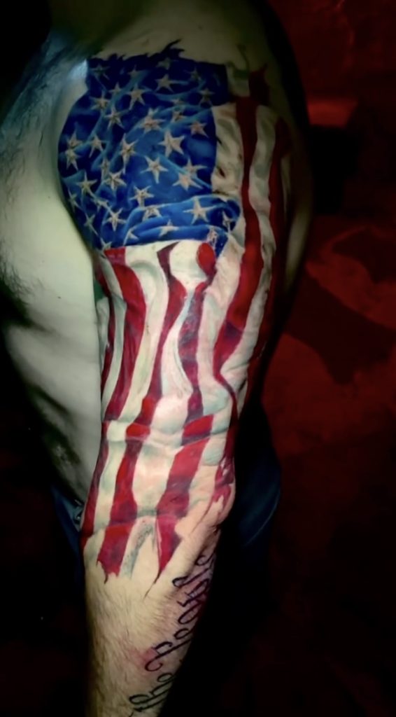 Full-color American flag sleeve tattoo honoring military service.