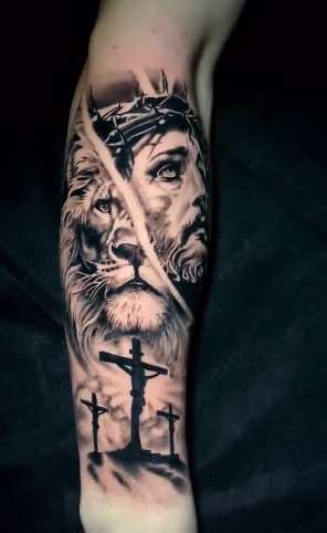 Black and grey realism tattoo by Jason “Elvis” Martin, depicting Jesus crowned with thorns alongside a lion and three crosses.
